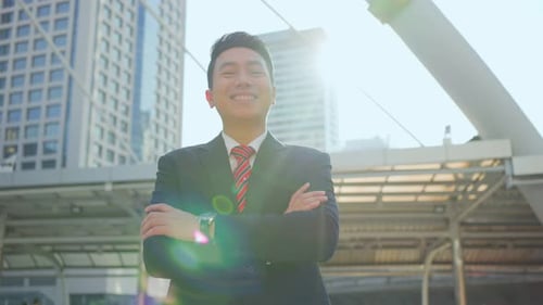 Asian handsome smart businessman standing outdoor with smile, working in company office in city.