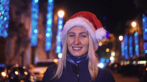 Woman Wearing Santa Hat Smiling at Night