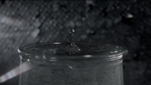 Water Droplets Ripple in Clear Glass Container