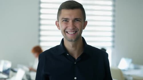 Close-up Portrait of Happy Office Worker Looking at Camera in Modern Office, Positive Male Employee