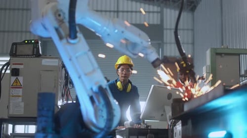technical engineer manage keying programing movement of modern welding robot arm