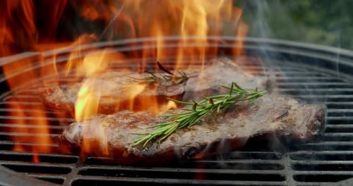 Steaks Sizzle on Fiery Grill with Rosemary