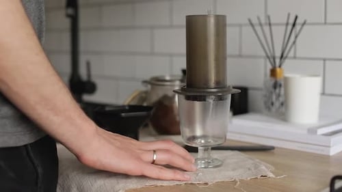 Man Prepares Coffee with Aeropress in Kitchen