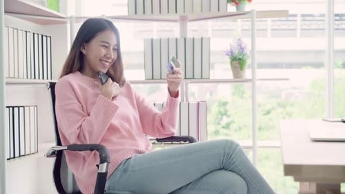 Woman Using Phone and Credit Card Indoors