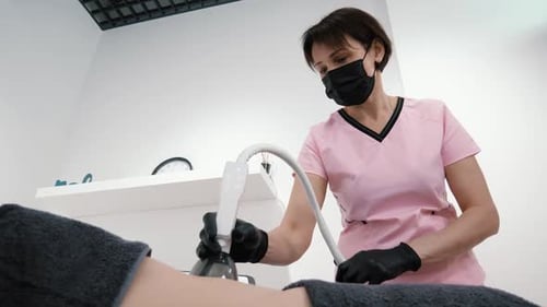 Woman Administering Beauty Treatment with Handheld Device