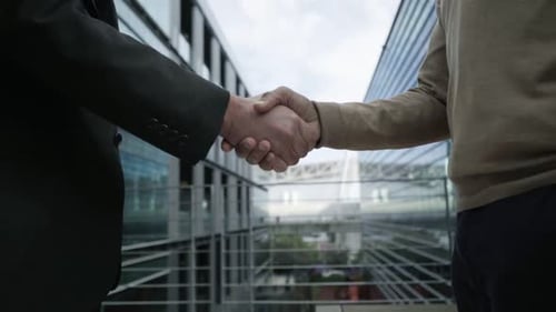 Zwei Geschäftsleute treffen sich über Verbindung zwischen Bürogebäuden