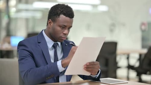 Afrikanischer Geschäftsmann liest Dokumente im Amt