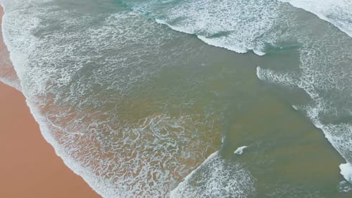 Aerial View of Sea Waves Break on Yellow Sand Beach