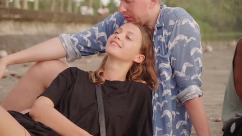 Woman Smiling while Spending Time with Boyfriend and Friends at Beach