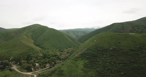 Scenic Aerial View of Mountain Hills With Paragliders