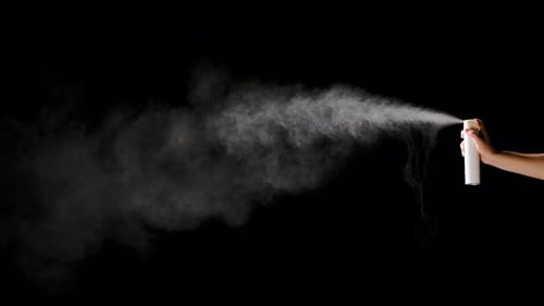 Männerhand Sprays Desinfektions-Aerosolspray auf schwarzem Hintergrund. Coronovirus-Schutz und