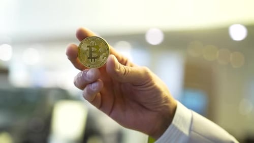 Hand Holding a Gold Bitcoin Cryptocurrency Token