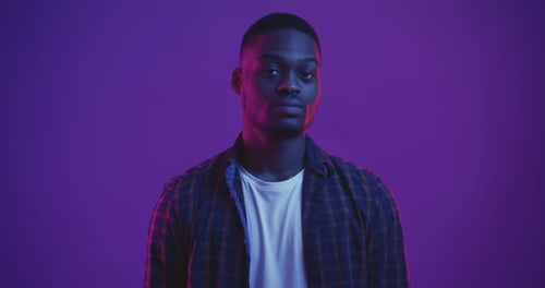 Young Adult Making OK Sign in Neon Lighting