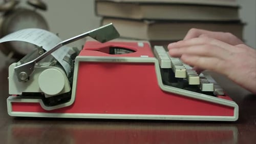 Hands Typing on Red Vintage Typewriter Close Up