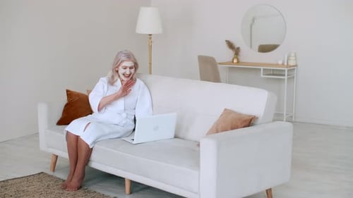 Woman in Robe Video Chatting with Face Mask