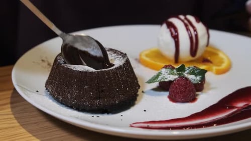 Chocolate Fondant. Girl Eating Sweet Dessert in a Restaurant. Lifestyle