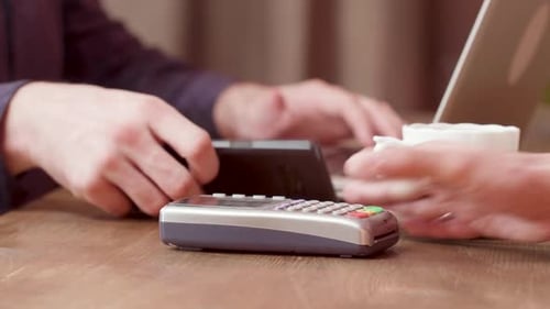 Man Pays with His Smartphone for a Coffee
