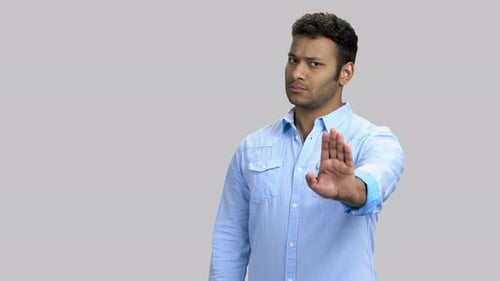 Young Adult Gestures Stop with Hand Up