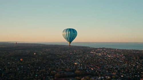 Hot Air Balloons Float Over City at Sunset