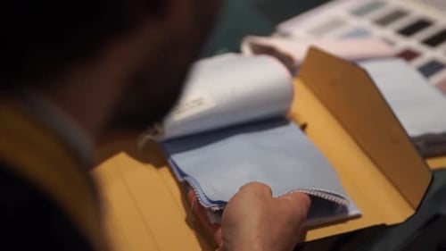 Man Inspecting Fabric Swatches for Tailoring
