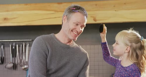 Playful Father Getting Hair Brushed by Daughter