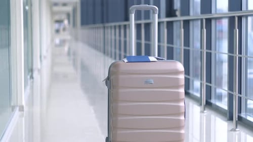 Suitcase and Passport at the Airport Terminal