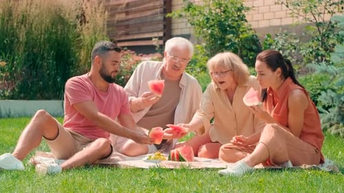 Family Sharing Watermelon at Sunny Summer Picnic