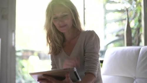 Blonde Woman Using Tablet Device at Home