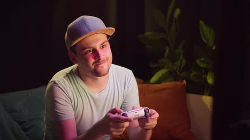 Excited Young Man Plays Video Games at Night