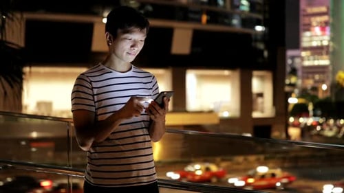 Young man using smart phone in city
