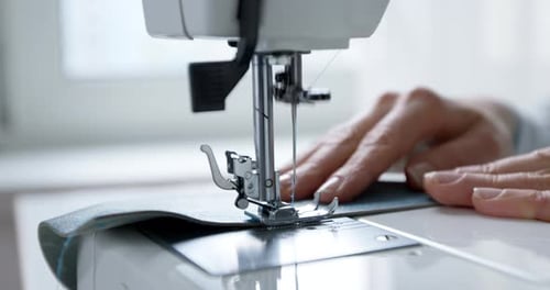 Une couturière travaille sur une machine à coudre. Gros plan d'une aiguille et d'un fil. Créateur de vêtements Tailleur.