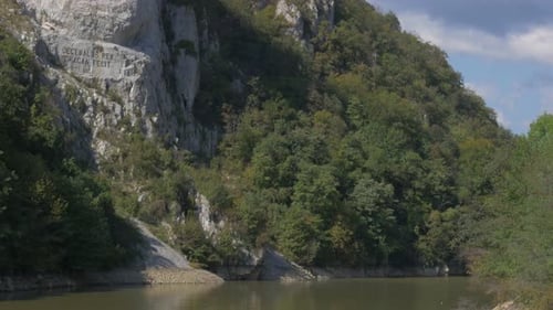 Sculpture du roi dace Decebalus Rex 4K 2160p vidéo UHD - Tête de Decebalus incisée dans la pierre près d'une rivière
