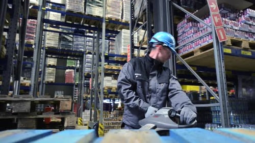 Worker Riding Warehouse Lifter