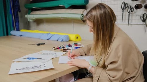 Woman Fashion Designer Sketches at Workplace