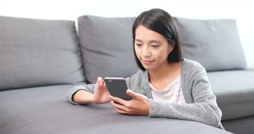 Woman Using Smartphone on Couch Indoors
