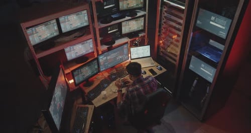Hacker Using Computer with Multiple Monitors