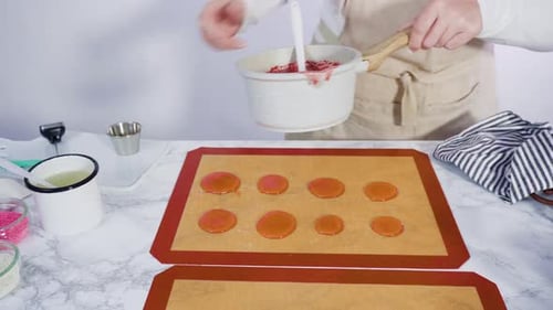 Step by step. Pouring caramelized sugar on a silicone baking mat to make homemade lollipops.