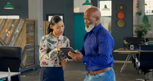 Coworkers Discussing a Tablet in a Modern Office
