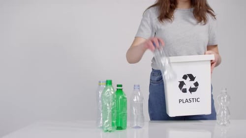 Adult Recycling Various Plastic Bottles in a White Bin