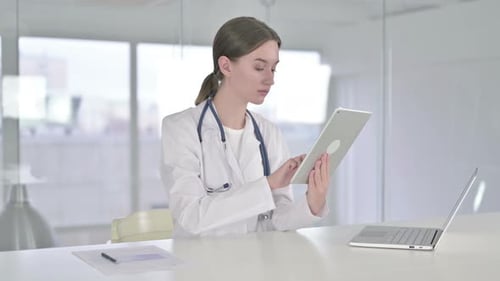 Hardworking Young Female Doctor Using Tablet in Modern Office
