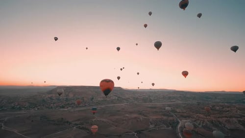 Hot Air Balloons Rising Over Landscape at Sunrise