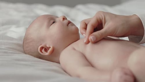 Hübscher neugeborener Junge bekommt Bauchmassage von Mutter