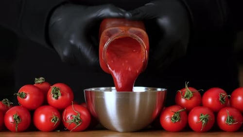 Tomato Sauce Being Poured into Bowl from Jar