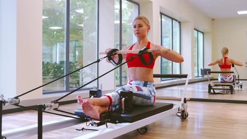 Blonde Woman Exercising on Pilates Machine