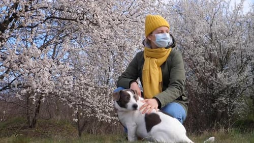 Woman Wearing Face Mask Walking With Dog Outdoors During Coronavirus Pandemic.