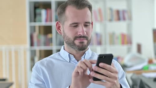 Man Using Smartphone in Modern Office Setting