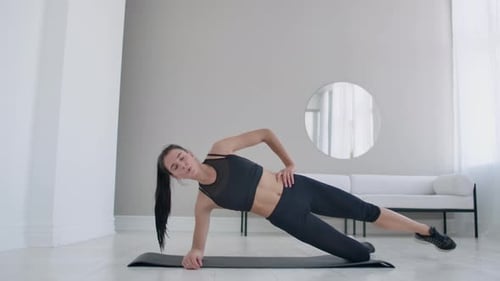 Woman Does Side Plank Leg Lifts in Living Room