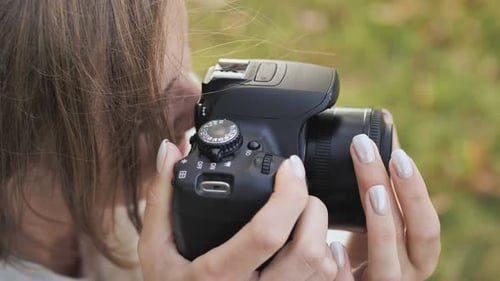 The Girl Takes Pictures of Nature in the Park in the Summer