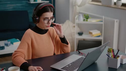 Jeune femme assistant à une réunion d'appel vidéo sur ordinateur portable avec casque