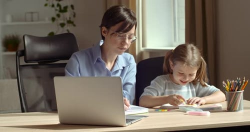 Adult and Child Working Together at a Desk